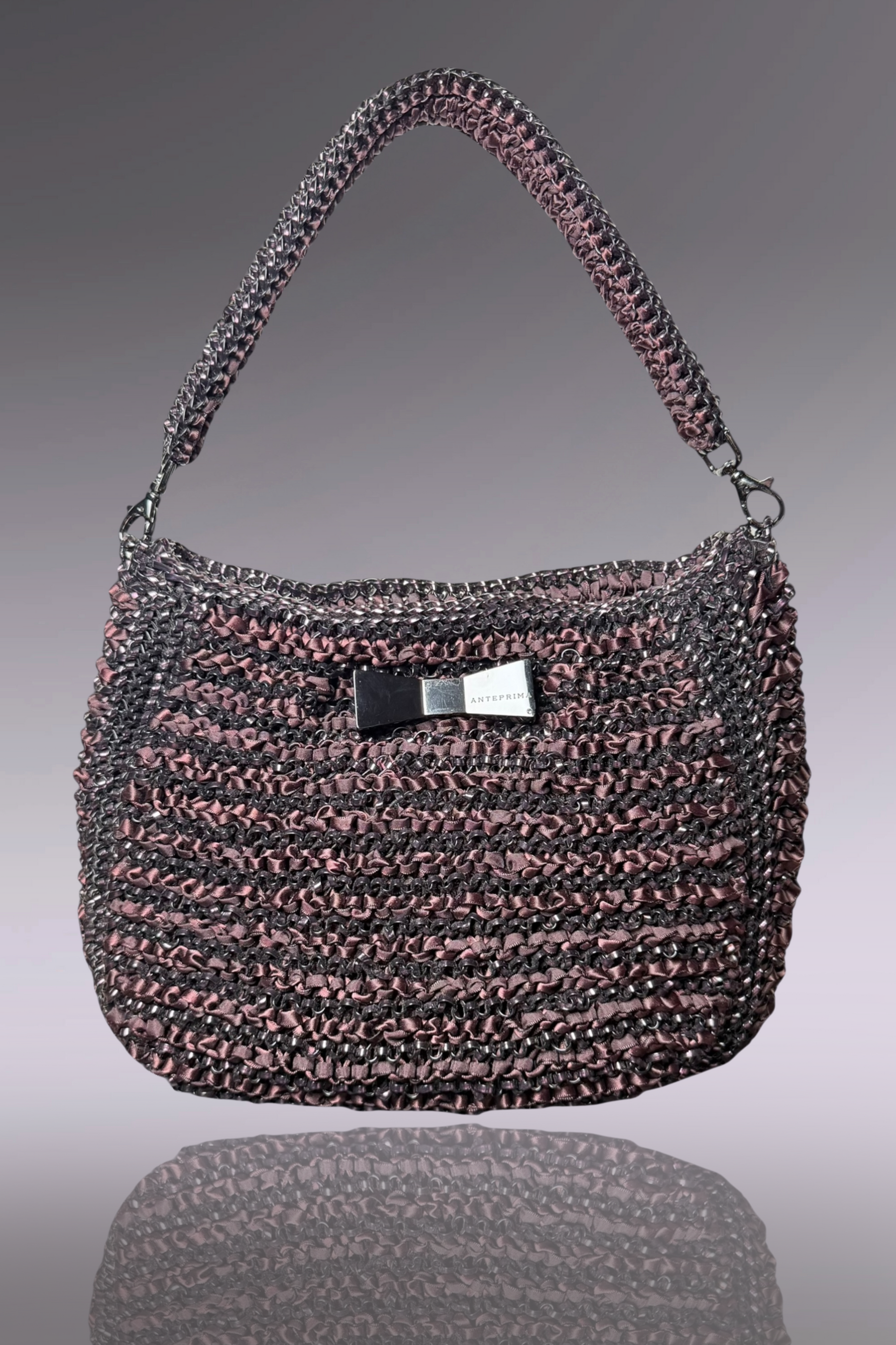 Handbag with a bow detail on a reflective surface