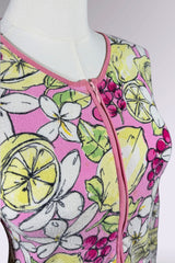 Mannequin wearing a top with a colorful lemon and flower pattern on a grey background