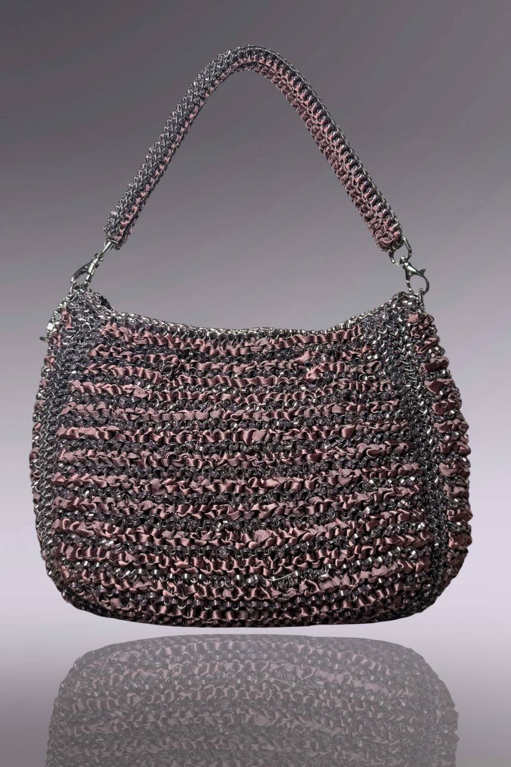 Textured handbag with a reflective surface on a gradient background