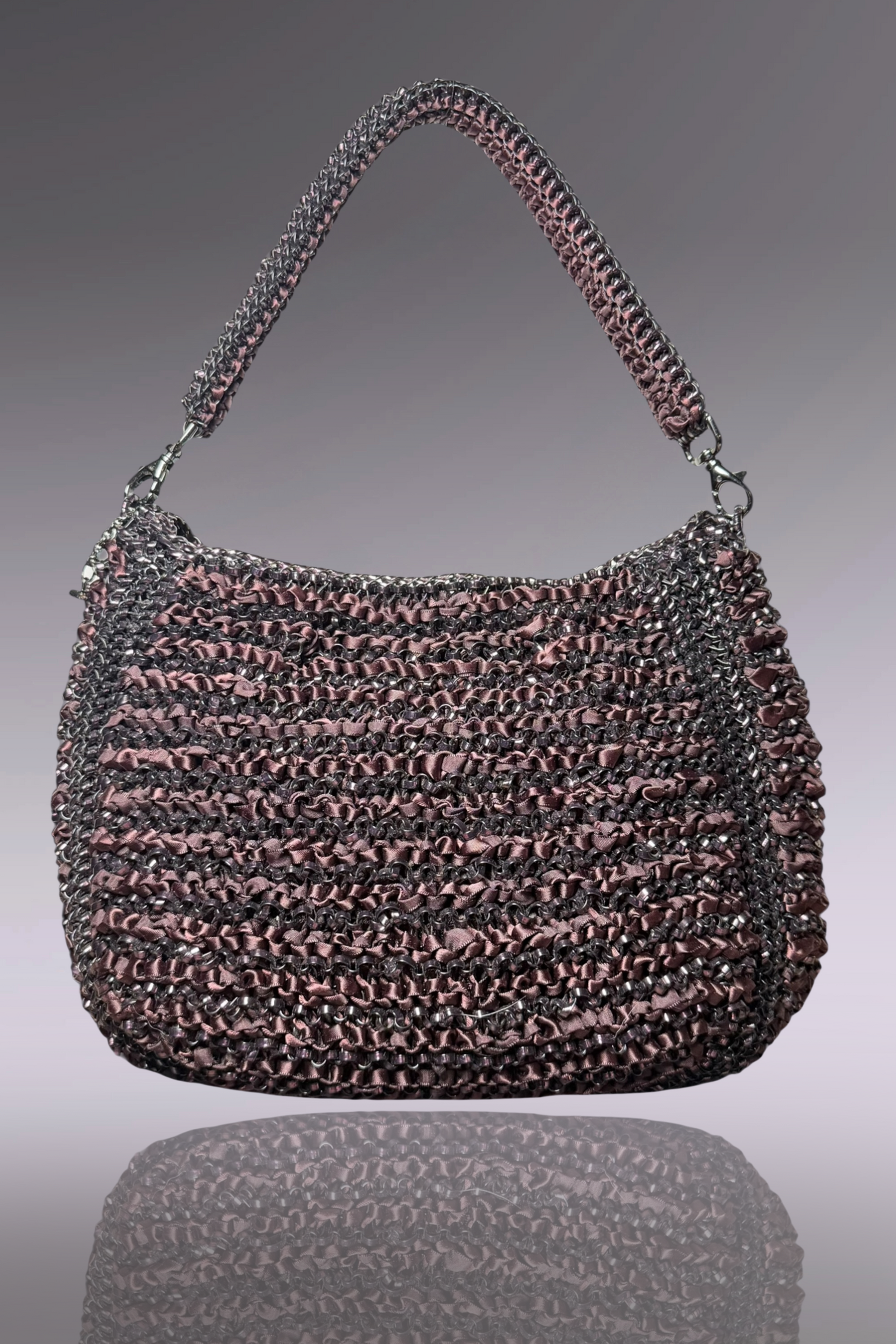 Textured handbag with a reflective surface on a gradient background