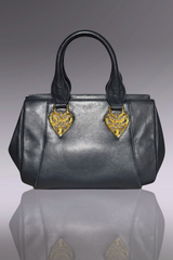 Gray handbag with gold heart-shaped embellishments on a reflective surface