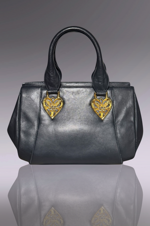 Gray handbag with gold heart-shaped embellishments on a reflective surface