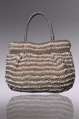 Handbag with a textured pattern on a reflective surface