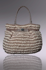 Handbag with a textured pattern on a reflective surface