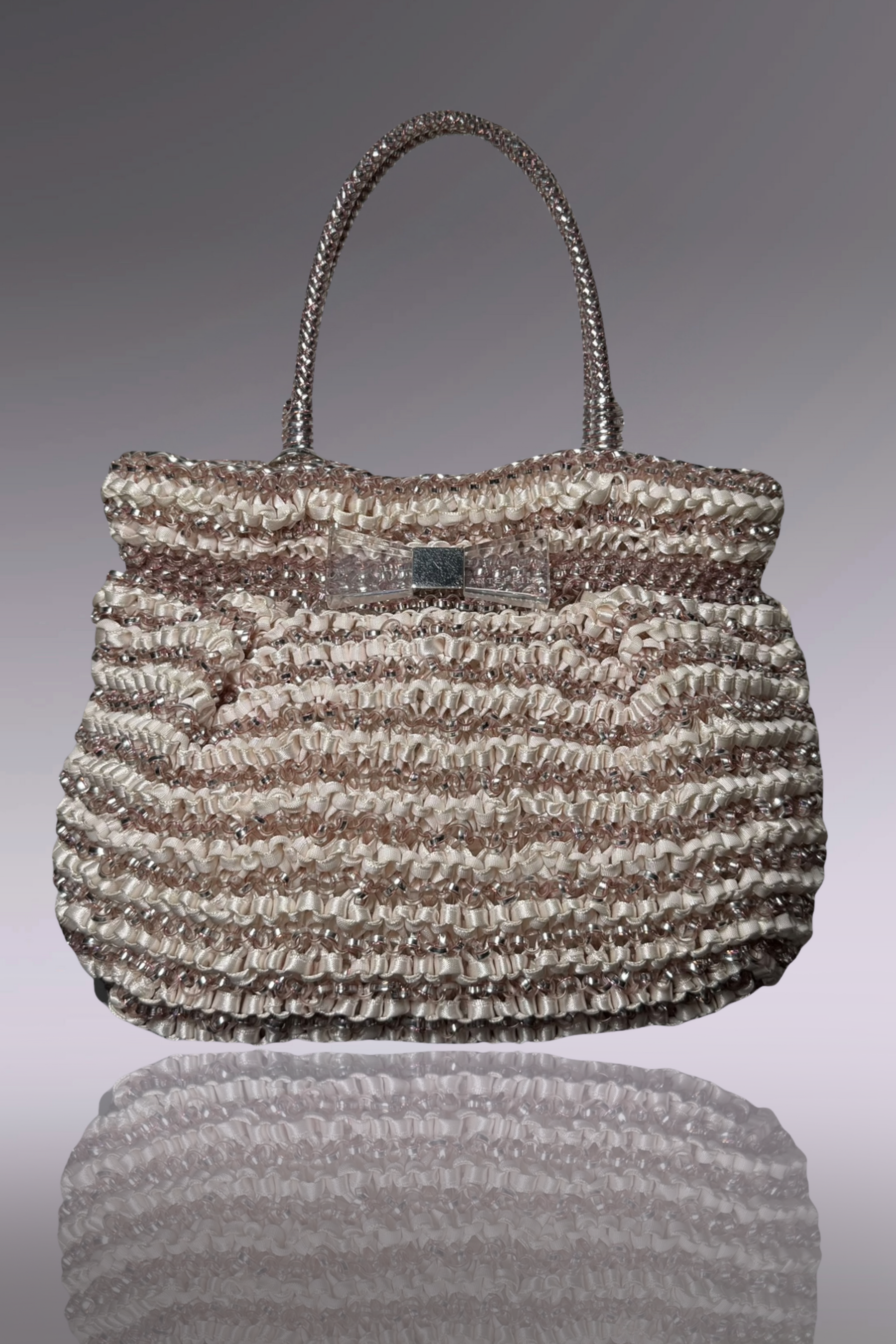 Handbag with a textured pattern on a reflective surface
