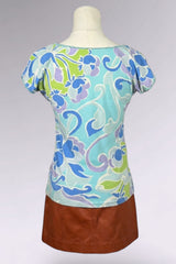 Colorful patterned top with a brown skirt on a mannequin against a gray background