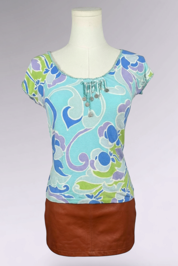 Colorful floral top with a brown skirt on a mannequin against a gray background