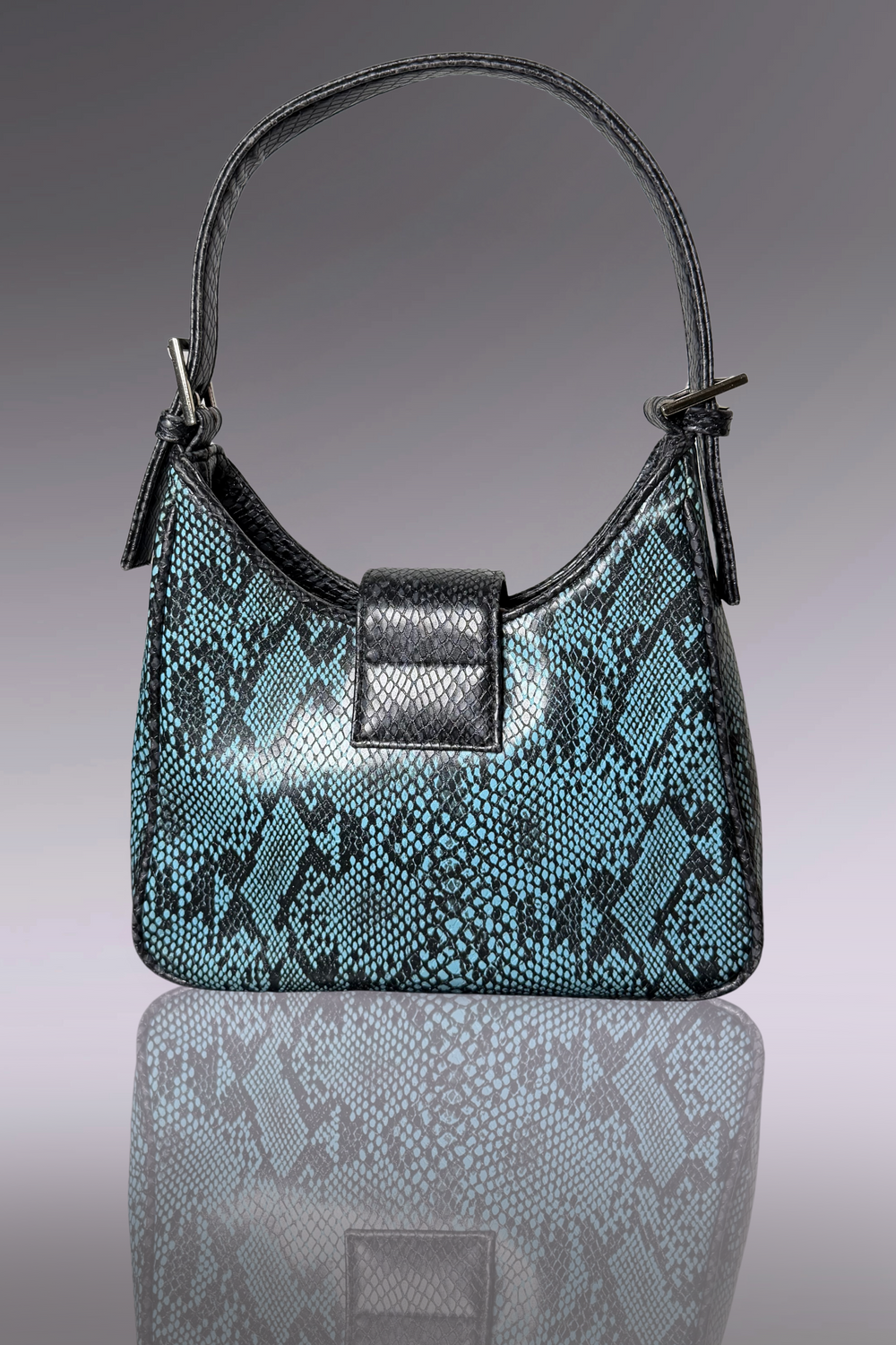 Teal snake skin patterned handbag with black accents on a reflective surface.