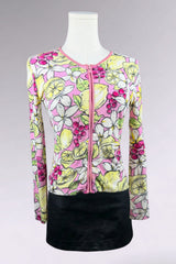 Colorful floral and fruit patterned top on a mannequin against a gray background