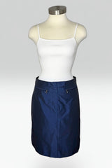 A navy blue mini skirt displayed on a mannequin torso, styled with a white ribbed camisole top against a light gray studio background.