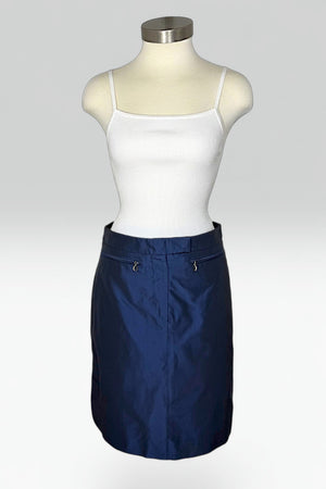 A navy blue mini skirt displayed on a mannequin torso, styled with a white ribbed camisole top against a light gray studio background.